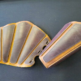 A close up of a pair of Mercenary Vambraces on a table.