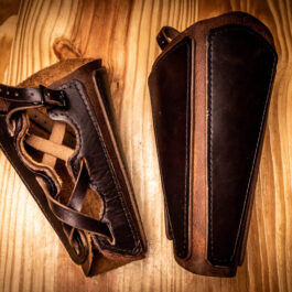 a pair of mercenary vambraces on a wooden table