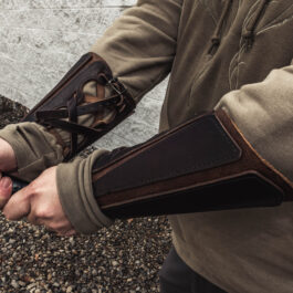 a pair of mercenary vambraces worn by a man with a sword