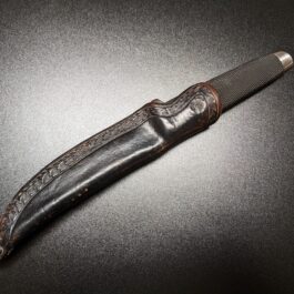 A custom leather sheath that is sitting on a table.