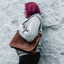a woman holding the solvang tote in horween dublin english tan