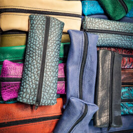 A pile of Mystery Zip Pouches, each a different color, sitting on top of each other.