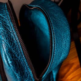 a cobalt blue mini backpack with black straps and hardware